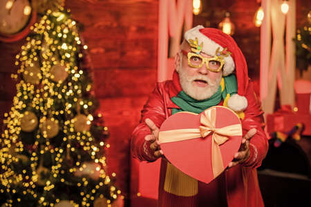 Be happy. stack gifts under Christmas tree. presents from santa with love. happy man with beard. xmas decoration. happy new year at home. winter holiday shopping. party celebrationの写真素材