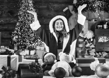 santa woman feel happiness in new year. girl santa among xmas gifts and presents box. black friday shopping. house party with christmas cookie. happy girl made cookies for santaの写真素材