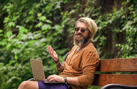 You can work anywhere. Hipster inspired work in park. Agile business. Bearded guy sit on bench in...