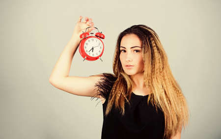 Pretty girl managing her time. Woman hold vintage alarm clock. Watch repair. Time management. Punctuality and discipline. Practice of advancing clocks. Daylight saving time. Change time zone.の写真素材