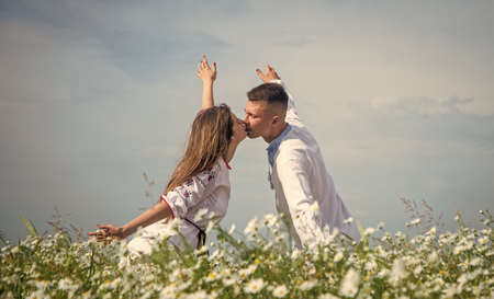Young and free. romantic relationship. beautiful couple in love. man and woman in chamomile flower field. summer vacation. happy family among flowers. spring nature beauty. love and romanceの写真素材
