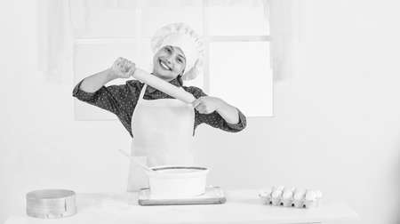 kitchen utensil. kid in chef uniform and hat. teen girl preparing dough. making cake by recipe. time...