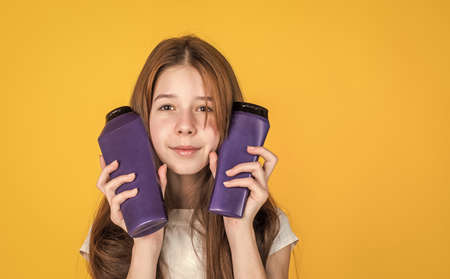 cute child girl has trendy hairstyle and use lotion in bottle, beauty cosmeticの写真素材