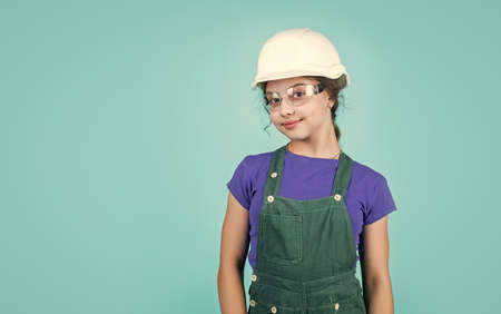 teen girl builder in protective helmet and uniform, childhood development, copy spaceの写真素材