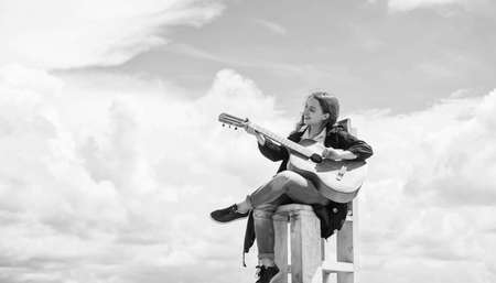 Funky beauty. female singer and guitarist. happy childhood. cute child play guitar outdoor. music and song. vocal school. beautiful teen girl with acoustic guitar. kid country fashion styleの写真素材