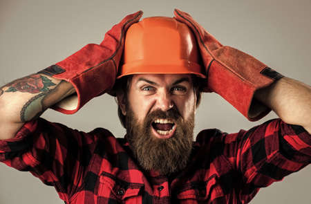 shocked assistant. engineering concept. repair tool shop. bearded man worker in helmetの写真素材