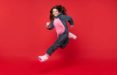 happy kid wear soft night suit. full length. child jump in cozy sleepwear. sweet dreams.の写真素材