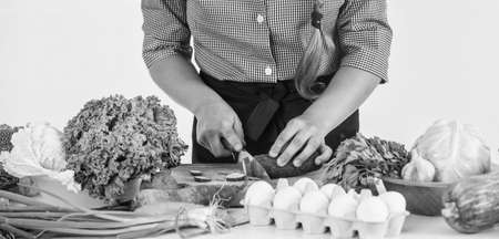 Imagine a new taste. professional chef cut with knife. child in cook fresh salad. girl at kitchen.の写真素材