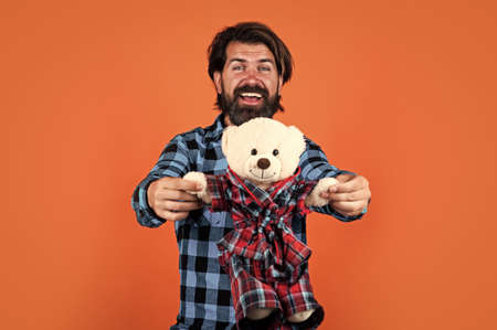 his favorite toy. toy shop concept. brutal handsome man with moustache. mature guy playing. happy birthday gift. happiness and joy. bearded hipster hugging fluffy teddy bear toyの写真素材