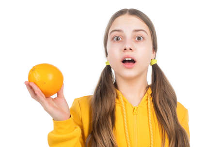 amazed teen girl with orange citrus fruit. vitamin and dieting. child eating healthy food.の写真素材