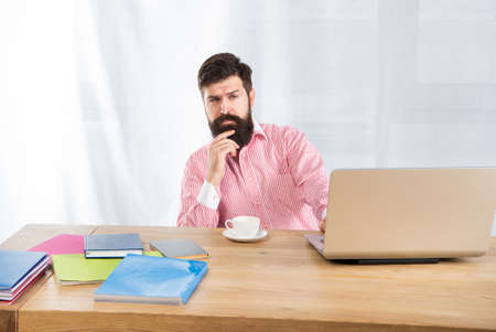 Serious man thinking sitting at office desk. Office work