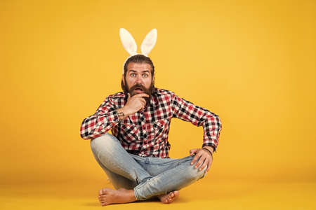 Easter is coming.. happy easter. funny bearded man wear bunny ears. guy in rabbit costume having fun. spring holiday party celebration. egg hunt. brutal happy man on yellow background. funny bunnyの写真素材