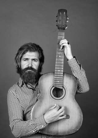 vintage music shop. bearded man being a rock star. casual male guitarist. concept of music and vocal. man playing the acoustic guitar. brutal man with moustache and beard hold guitarの写真素材