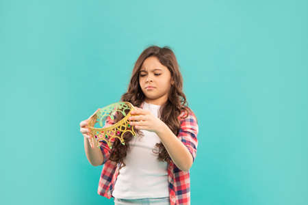 unhappy child holding crown. self confident queen. expressing smug. arrogant princessの写真素材