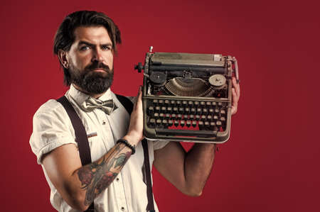 handsome bearded journalist in bow tie hold a typewriter, writerの写真素材