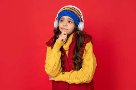 winter fashion. teen girl in hat and earphones. modern life in childhood.の写真素材