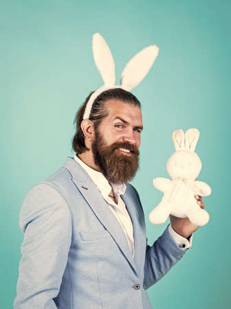 nice toy. brutal handsome man with moustache. mature guy wear rabbit ears. happy easter. spring holiday and party. funny bearded hipster in bunny ears. celebration conceptの写真素材