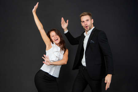 happy man and woman in business look having fun on black background, corporate partyの写真素材