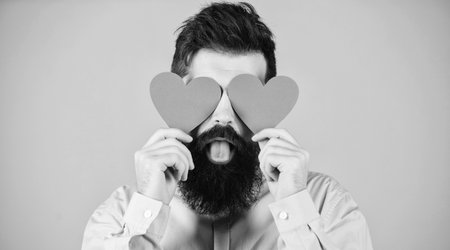 Love is blind. Hipster covering eyes with small hearts. Sexy valentine man with heart shaped...