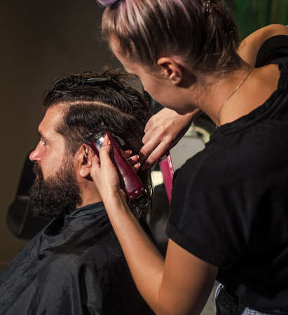master Barber does the hairstyle and styling with electric shaver to guy, Concept Barbershop