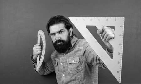 formal education. male student at mathematics school lesson. pass the math exam. learning the subject. serious man with beard using triangle ruler. studying the measurementの写真素材