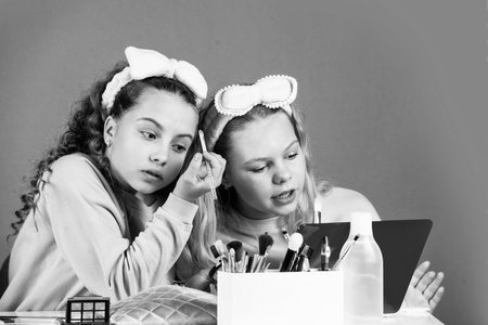 Hobby and fun. Cosmetics for children. Spa party. Sisterhood happiness. Skin care. Kids makeup. Beauty and fashion. Happy girls doing makeup. Beauty salon. Play with cosmetics. Cosmetics shopの写真素材