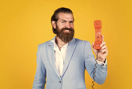 handsome caucasian businessman with trendy hairstyle in jacket speak on vintage phone, digital age