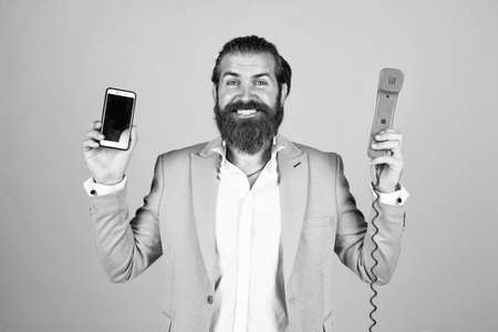 well groomed man in wedding formalwear has beard use retro phone and modern smartphone, modern life