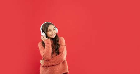 happy child listen music in headphones. kid wear sweater. express positive emotion.の写真素材