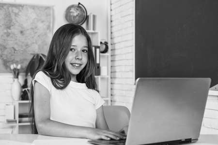 modern education. knowledge day. child pupil sit at table and use computer. girl is college student....