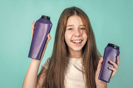 cute child girl has trendy hairstyle and use lotion in bottle, beauty shoppingの写真素材