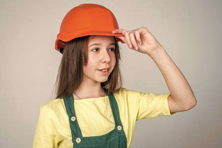 teen girl in helmet and boilersuit. child wear hard hat. kid builder on construction site. worker engineer. architect in workshop. renovation and repair. Confident mechanicの写真素材