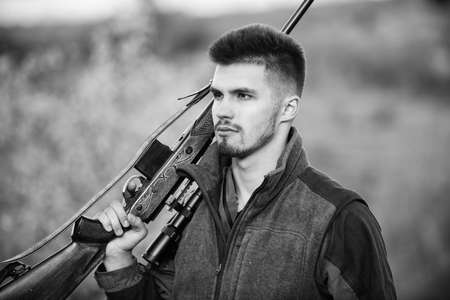 Masculine hobby activity. Hunting season. Man bearded hunter with rifle nature background. Experience and practice lends success hunting. How turn hunting into hobby. Guy hunting nature environmentの写真素材