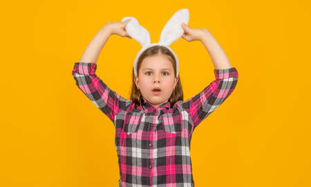 amazed easter child in bunny ears on yellow backgroundの写真素材
