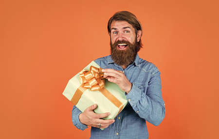 mature man with beard and trendy hairstyle hold gift box, discount