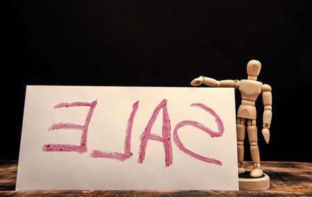 Sale. Wooden dummy and sale handwritten. Advertising sign. Advertisement and promotionの写真素材