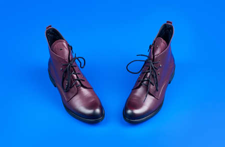 brown boots. ankle boots on blue background. shoe store. shopping concept.の写真素材