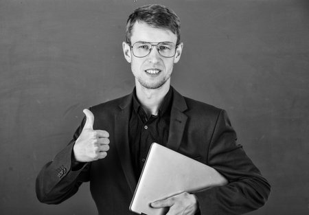 modern education concept. young but skilled businessman. typical office worker. man wear glasses and jacket. back to school. university teacher at blackboard. student study on laptopの写真素材