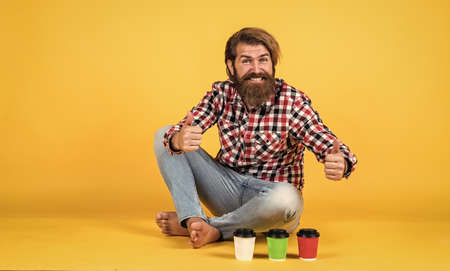 Caucasian mature hipster with trendy hairstyle in checkered shirt choose morning coffee from paper cup, coffee shopの写真素材