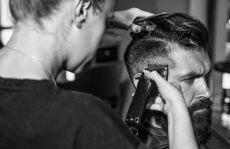 Close-up of barber styling beard to male in barbershop, Personal stylist barber