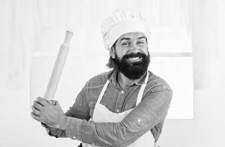 mature bearded hipster wear chef hat while cooking food in kitchen using rolling pin, kitchen utensilの写真素材