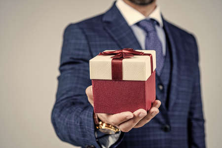 Wrapped box in male hand. selective focus. Box tied with ribbon. Gift shop.の写真素材