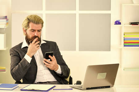 Multitasking. confident brutal businessman. Elegant businessman analyzing data in smartphone....