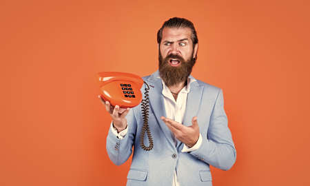 handsome caucasian businessman with trendy hairstyle in jacket speak on vintage phone, callの写真素材