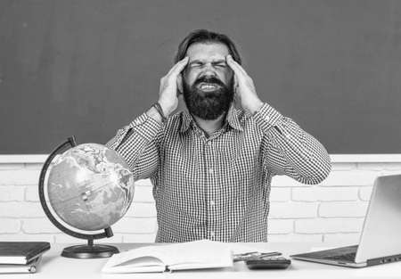 male student sit in school classroom while hard lesson. pass the exam. learning is hard. stressed hipster teacher. overworked man with beard having stressの写真素材