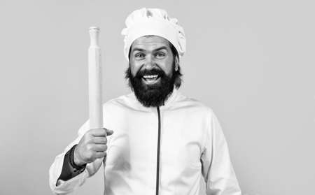 mature bearded man wear chef hat hold rolling pin. male cook ready for preparing food. brutal...