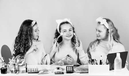 Happy girls doing makeup together. Sisterhood happiness. Cosmetics shop. Apply powder. Cream base tone. Prevent acne. Kids makeup. Skin care concept. Cosmetics for children. Beauty and fashionの写真素材