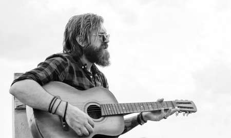 handsome bearded guy with stylish hair playing acoustic guitar, performanceの写真素材