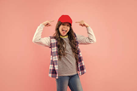 glad kid with curly hair in cap. teen hipster beauty hairstyle. female casual fashion model.の写真素材