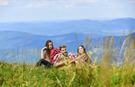 Real relaxation. romantic picnic in tourism camp. campfire songs. group of people spend free time together. family camping. hiking adventure. happy men and girls friends with guitar. friendshipの写真素材